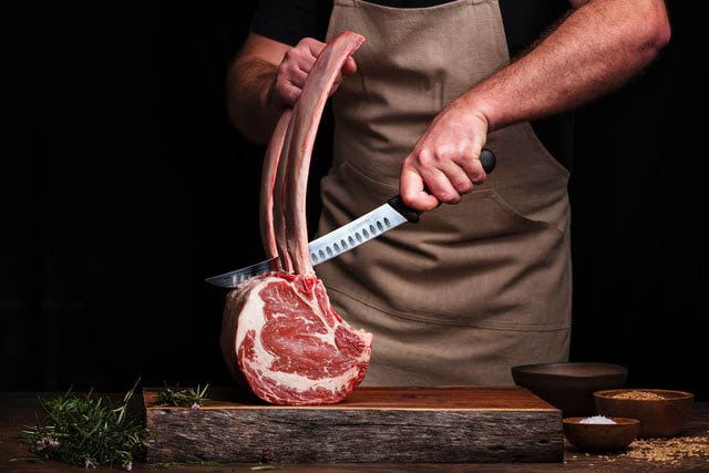 butcher cutting steak